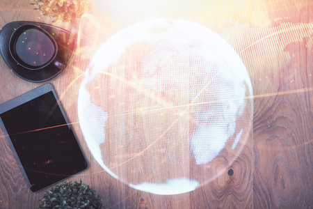 Double exposure of business theme hologram over desktop with phone. Top view. Mobile international trade connection concept.の写真素材