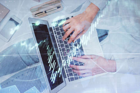 Double exposure of woman hands working on computer and forex graph hologram drawing. Top View....