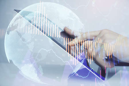 Multi exposure of mans hands holding and using a digital phone and forex graph drawing. Financial...