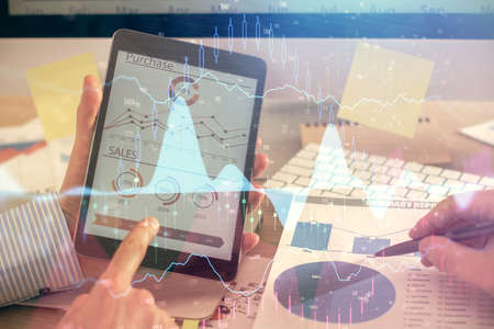 Multi exposure of mans hands holding and using a phone and financial chart drawing. Market analysis...
