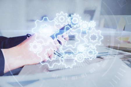 Double exposure of mans hands holding and using a phone and international business theme drawing.