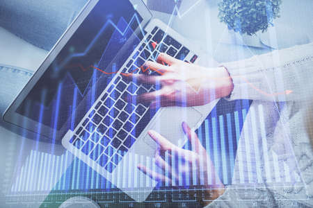 Double exposure of woman hands working on computer and forex chart hologram drawing. Top View....