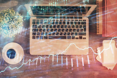 Stock market chart and top view computer on the table background. Double exposure. Concept of...
