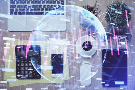 Double exposure of forex chart hologram over desktop with phone. Top view. Mobile trade platform concept.の写真素材