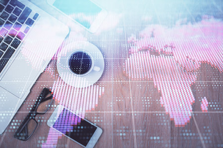 Double exposure of business theme hologram over desktop with phone. Top view. Mobile international trade connection concept.の写真素材