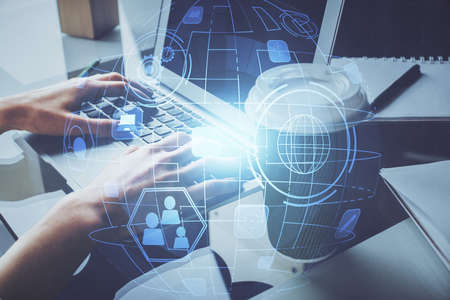 Double exposure of woman hands typing on computer and social network theme hologram drawing. People...