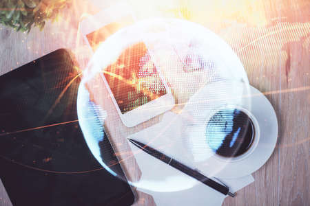 Double exposure of business theme hologram over desktop with phone. Top view. Mobile international...