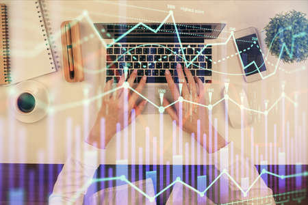 Double exposure of woman hands working on computer and forex chart hologram drawing. Top View....