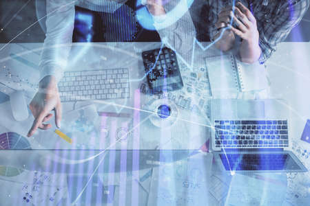 Double exposure of man and woman working together and financial graph hologram drawing. market...