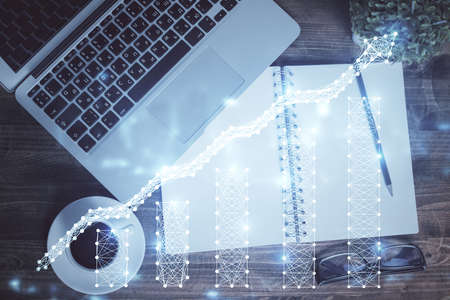 Financial market graph and top view computer on the desktop background. Double exposure. Investment concept.の写真素材
