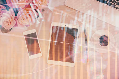 Double exposure of forex graph hologram over desktop with phone. Top view. Mobile trade platform...