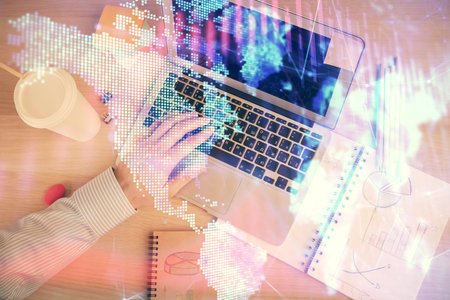 Double exposure of mans hands typing over computer keyboard and forex graph hologram drawing. Top...