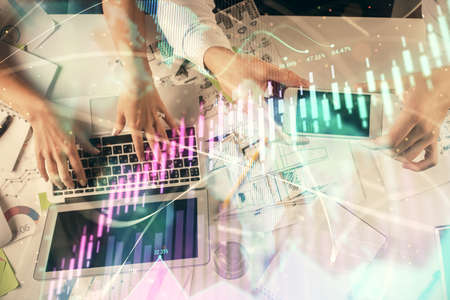 Multi exposure of man and woman working together and forex graph hologram drawing. Financial...