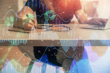 Double exposure of businesswoman hands typing on computer and forex chart hologram drawing....