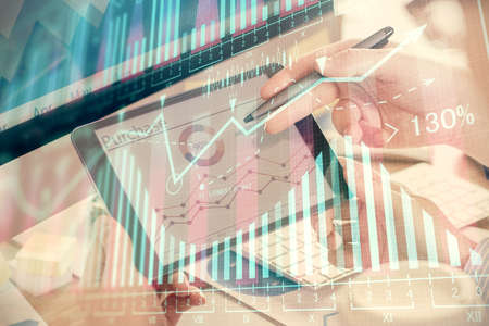 Double exposure of mans hands holding and using a phone and financial chart drawing. Market analysis...