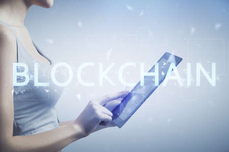 Double exposure of blockchain business sketch hologram and woman holding and using a mobile device.