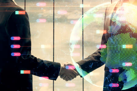 Double exposure of world map hologram and handshake of two men. International partnership concept.