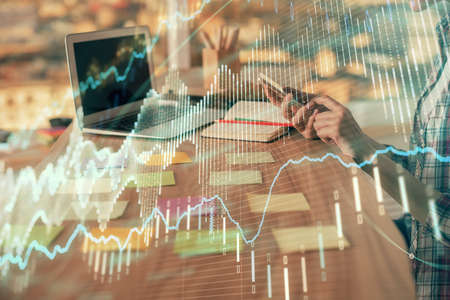 Double exposure of woman hands working on computer and forex graph hologram drawing. Financial...