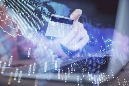 Double exposure of man hands holding a credit card and Forex graph drawing. Stock trading and...
