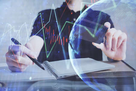 Double exposure of man hands holding a credit card and Forex graph drawing. Stock trading and...