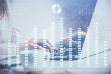 Double exposure of woman hands working on computer and forex graph hologram drawing. Financial...