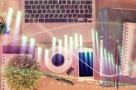 Double exposure of financial graph hologram over desktop with phone. Top view. Mobile trade platform...