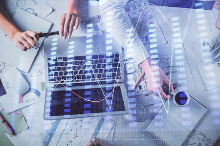 Double exposure of man and woman working together and financial graph hologram. Business concept....