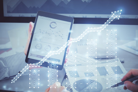 Double exposure of mans hands holding and using a digital device and forex graph drawing. Financial market concept.の写真素材