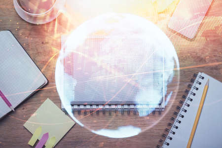 Double exposure of business theme hologram over desktop with phone. Top view. Mobile international trade connection concept.の写真素材