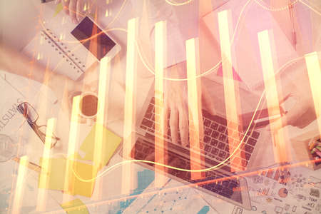 Multi exposure of mans hands typing over computer keyboard and forex graph hologram drawing. Top view. Financial markets concept.の写真素材