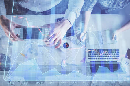 Double exposure of man and woman working together and financial chart hologram drawing. market...