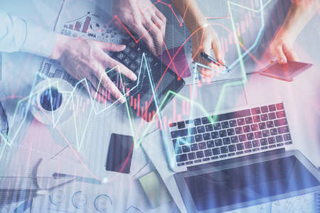 Double exposure of man and woman working together and financial chart hologram drawing. market...