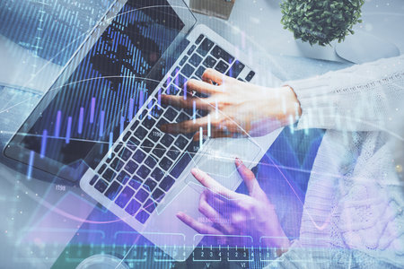 Double exposure of woman hands working on computer and forex chart hologram drawing. Top View. Financial analysis concept.の写真素材