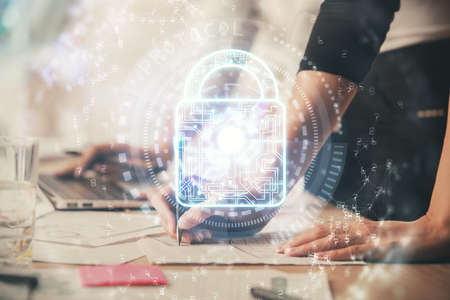 Double exposure of woman hands working on computer and lock hologram drawing. Security concept.の写真素材