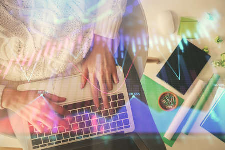 Multi exposure of woman hands working on computer and forex chart hologram drawing. Top View....