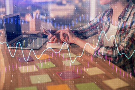 Double exposure of businesswoman hands typing on computer and forex graph hologram drawing. Financial analysis concept.の写真素材