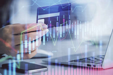 Multi exposure of woman on-line shopping holding a credit card and financial graph drawing. Stock...