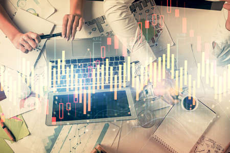 Double exposure of man and woman working together and financial graph hologram. Business concept....
