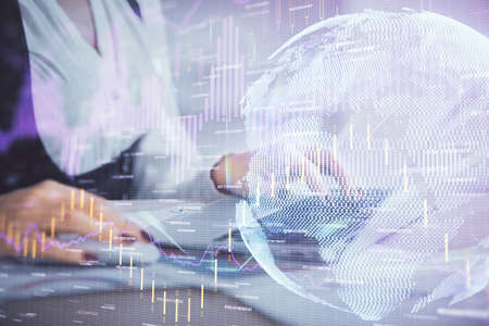 Double exposure of businesswoman hands typing on computer and forex graph hologram drawing....