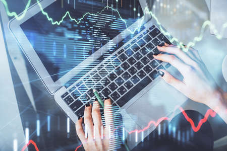 Double exposure of woman hands working on computer and forex chart hologram drawing. Top View....