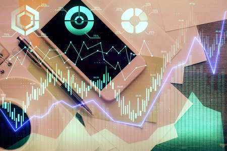 Multi exposure of forex graph hologram over desktop with phone. Top view. Mobile trade platform...