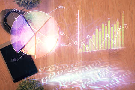 Multi exposure of financial chart hologram over desktop with phone. Top view. Mobile trade platform...