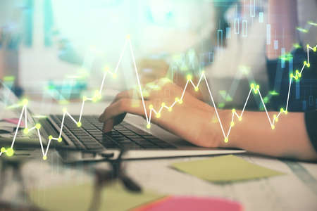 Multi exposure of woman hands typing on computer and financial graph hologram drawing. Stock market...