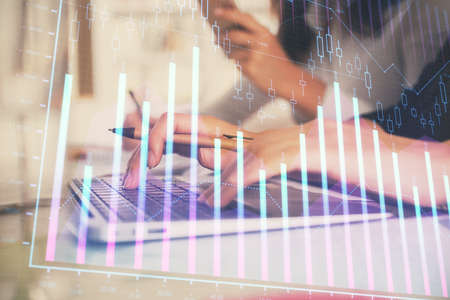 Multi exposure of woman hands typing on computer and financial graph hologram drawing. Stock market...