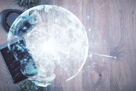 Double exposure of business theme hologram over desktop with phone. Top view. Mobile international...
