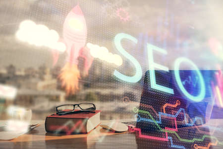 Multi exposure of SEO drawings and desk with open notebook background. Concept of Search optimizationの写真素材