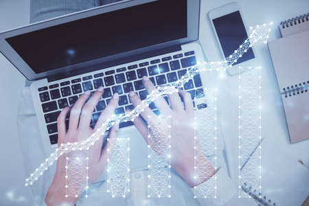 Double exposure of woman hands working on computer and forex chart hologram drawing. Top View. Financial analysis concept.の写真素材