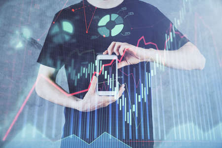 Double exposure of mans hands holding and using a digital device and forex graph drawing. Financial market concept.の写真素材