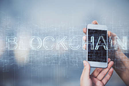 Double exposure of blockchain business sketch hologram and woman holding and using a mobile device.