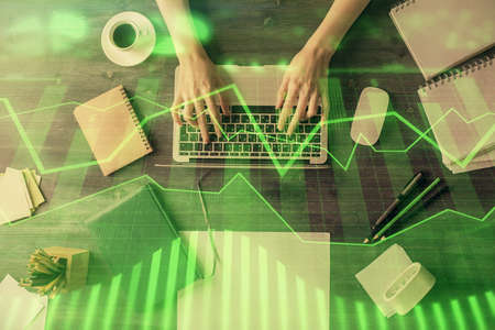 Multi exposure of woman hands working on computer and forex chart hologram drawing. Top View. Financial analysis concept.の写真素材